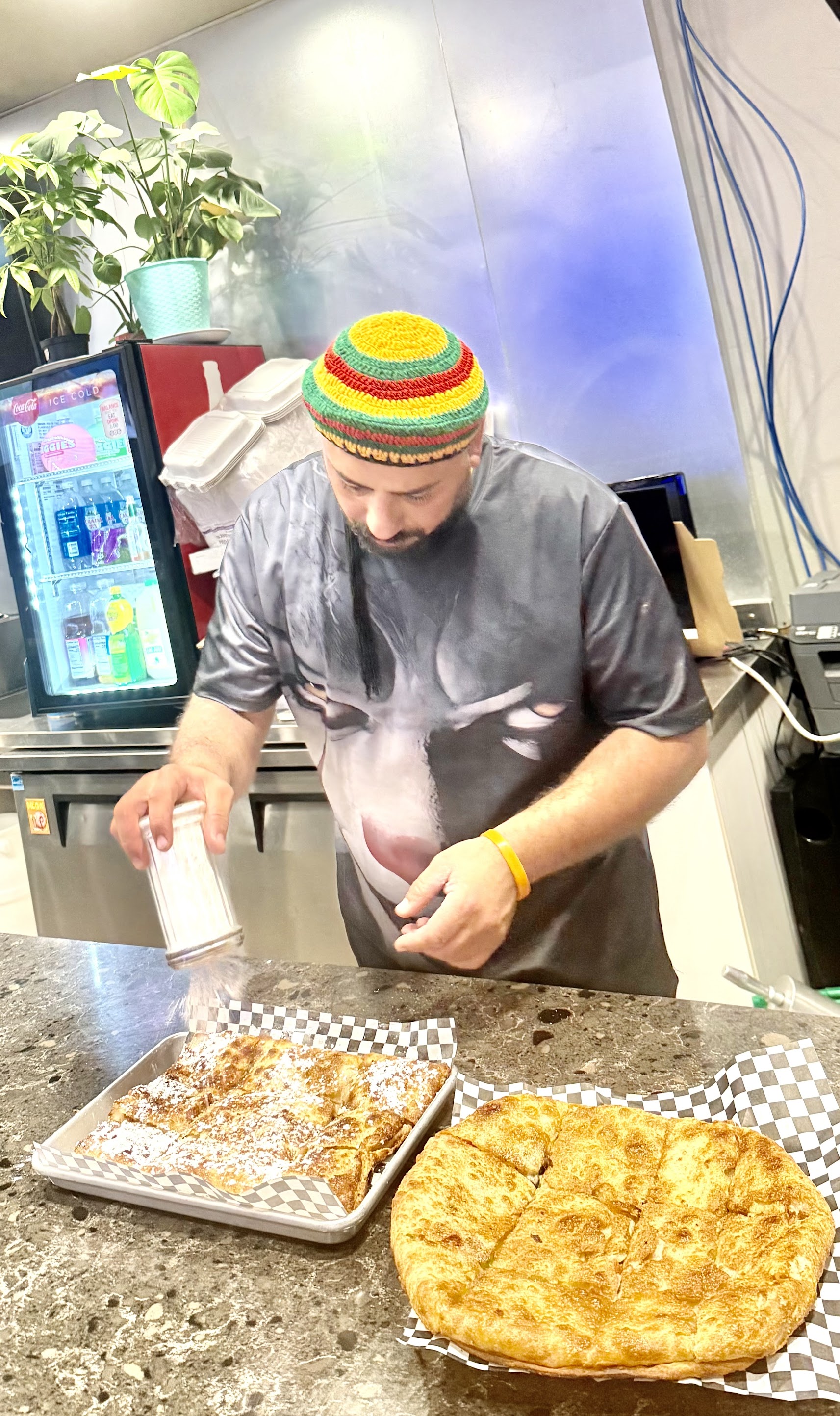 Hand-stretched Egyptian feteer being finished with powdered sugar at Shaltat in Hayward